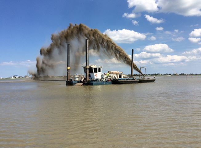 A dredge applies dredge material to enhance a wetland area