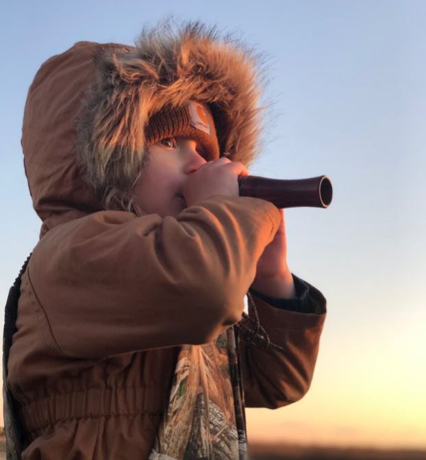 A child uses a duck call