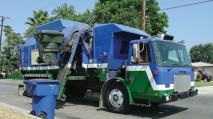 A truck lifts and empties a recycling cart