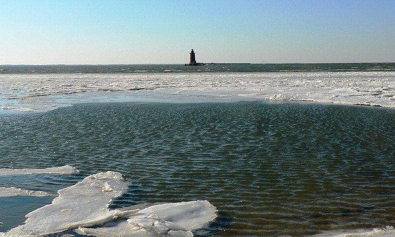 Floating ice on the Delaware Bay, just inshore from a lighthouse.