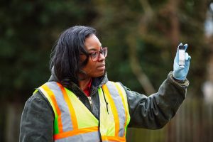 An engineer examines a water sample while working outdoors.