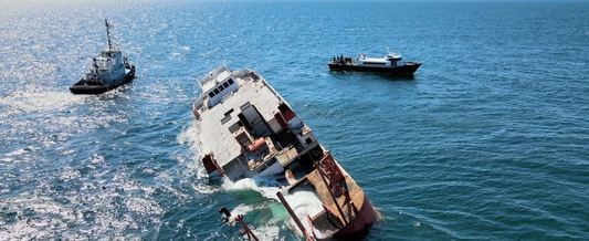 A surplus ship sinks into the ocean waters to provide fish habitat