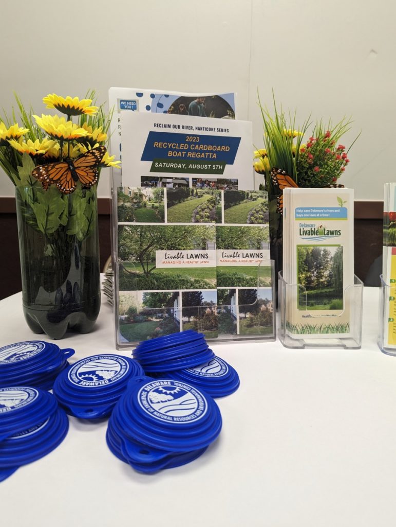 A table-top display of informative brochures flanked by flowers.