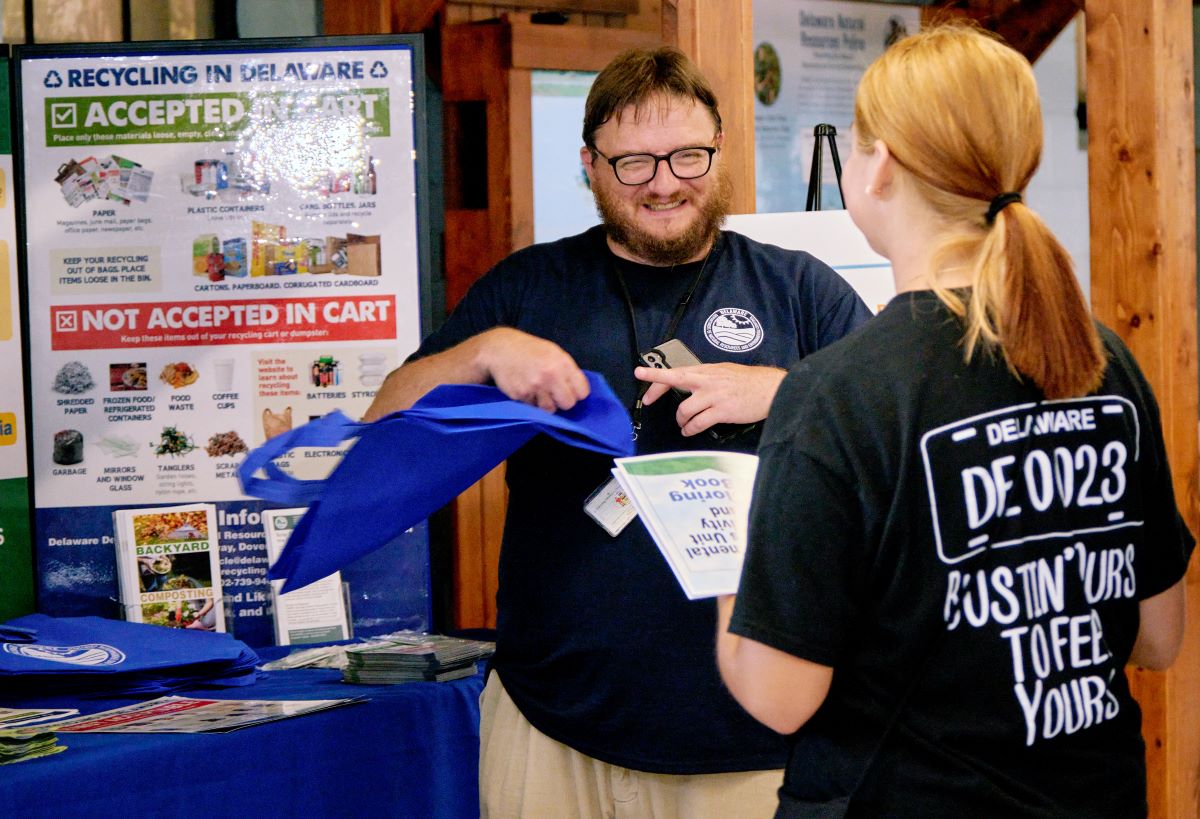 A DNREC staff person discusses recycling with a visitor at the Delaware State Fair. 
