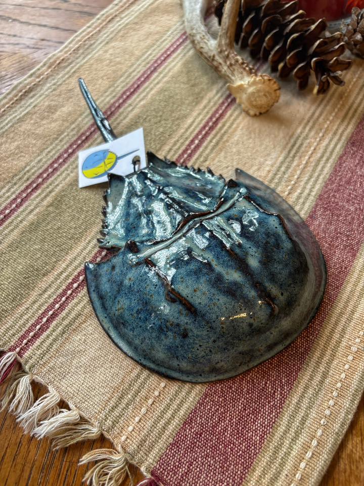 A ceramic horseshoe crab sits on a table.