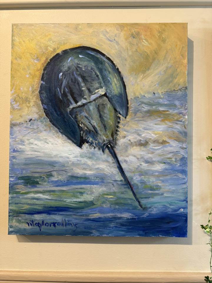 A painting of a horseshoe crab hangs on a wall.