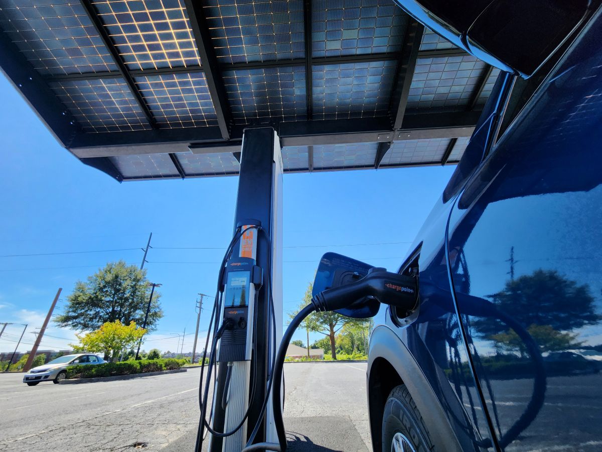 Closeup of an electric car plugged-in to a charger.