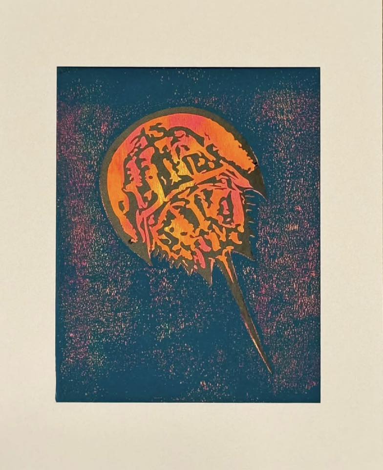 A painting of a horseshoe crab hangs on a wall.
