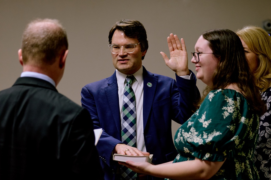 Secretary Greg Patterson takes the oath of office, with his hand on a Bible.