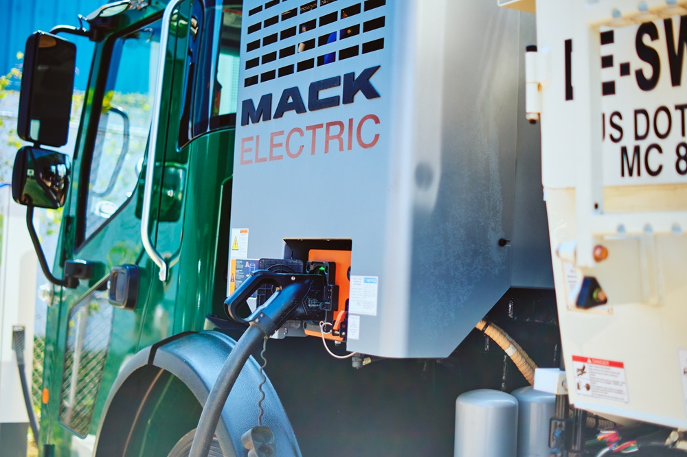An electric garbage truck charges.