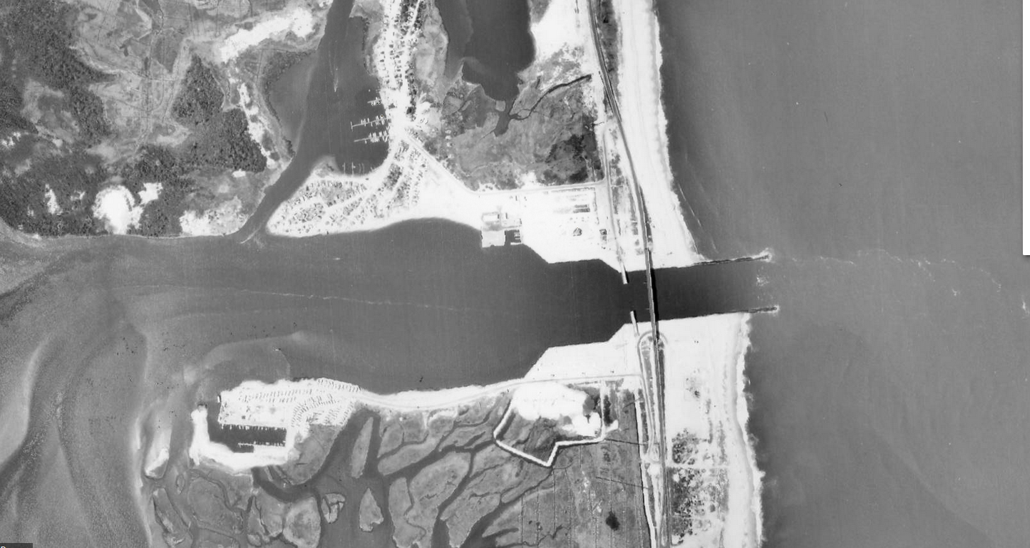 An aerial photo of a dredged and stabilized inlet connecting the ocean with inland bays.