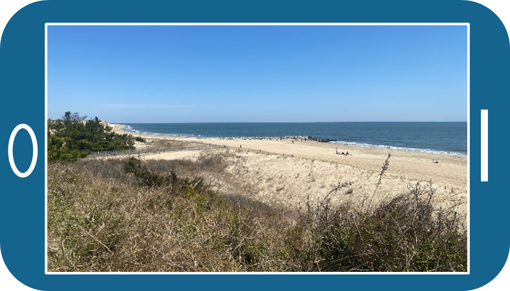 A view of a beach along the ocean framed by the body of a smartphone.