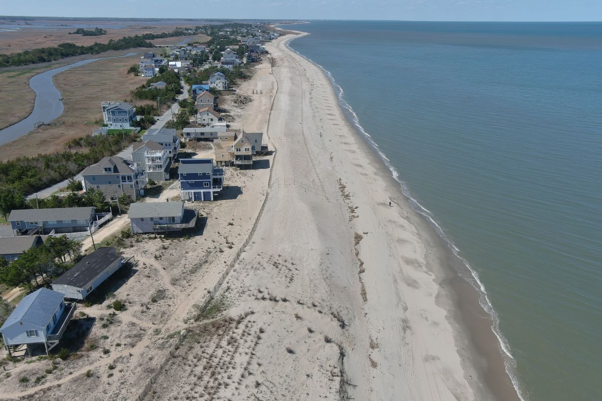 A view from above of a newly renourished beach with houses at the edge of the dune.